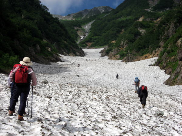 針ノ木大雪渓のノド手前を登る登山者